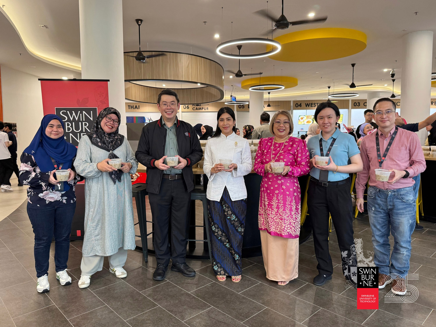 Members of Swinburne Sarawak’s leadership team – Ir Professor Sim Kwan Yong (third left), Professor Dr Ida Fatimawati bt Adi Badiozaman (centre), Ms Esty Sharkawi (third right) and Professor Brian Wong Kee Mun (right) – along with Swinburne Sarawak Staff Recreational Club members at the bubur lambuk distribution event.